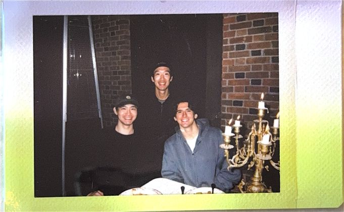 Three teammates at a candlelit table against a brick wall