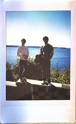 Two teammates on a stone wall above the water