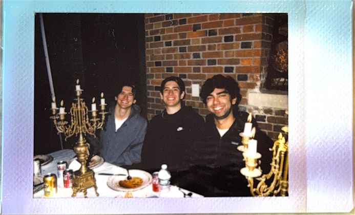Three teammates grinning between candelabras
