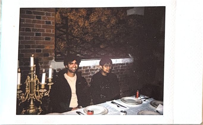 Two teammates at the long dinner table by candlelight